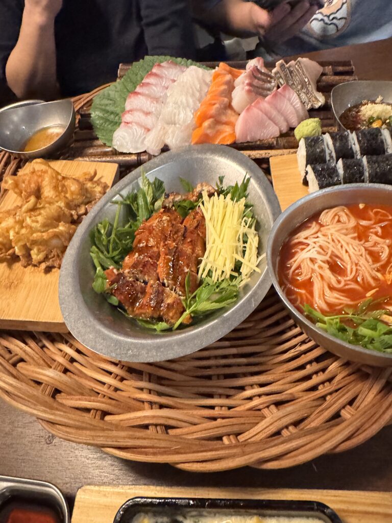 A generous spread of Korean aged sashimi (Suksung-hoe) with side dishes like corn cheese, pancakes, and salted rice balls at Maljiro, Kuala Lumpur.