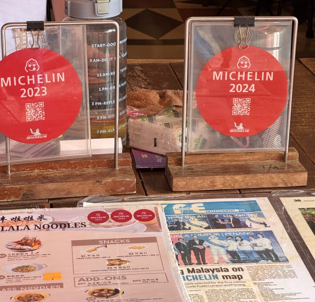 Michelin Bib Gourmand signs from 2023 and 2024 displayed at Lai Foong Lala Noodles in Kuala Lumpur.