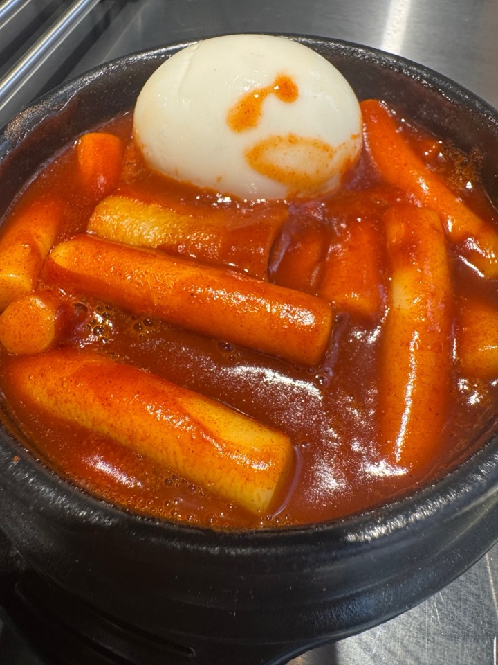 Maptteok (Spicy Korean rice cakes) in a ttukbaegi with a hard-boiled egg.
