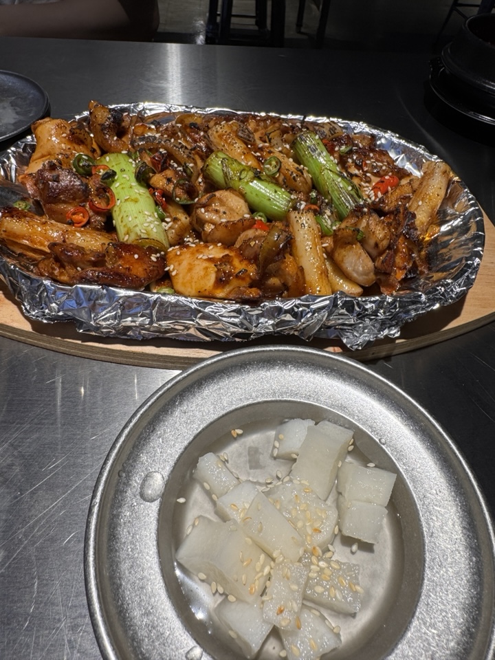 Mapkoba charcoal-grilled chicken with scallions and rice cakes, charred with a blowtorch.