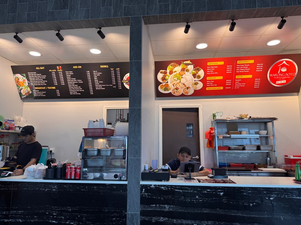 Local food stall counter and menu board at Etiqa Building food court