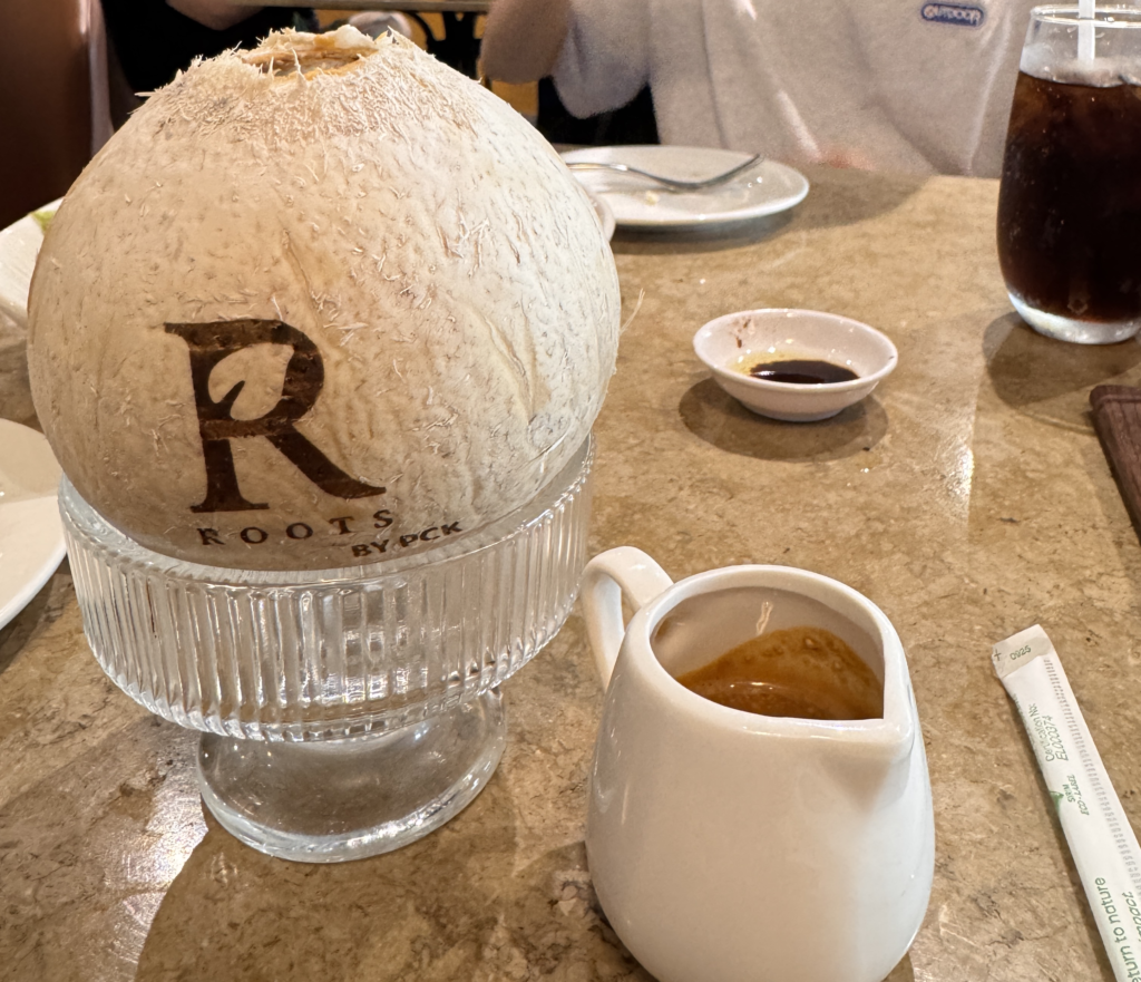 Sweetened espresso served inside a real whole coconut, a signature drink at Roots Bistro Bangsar.