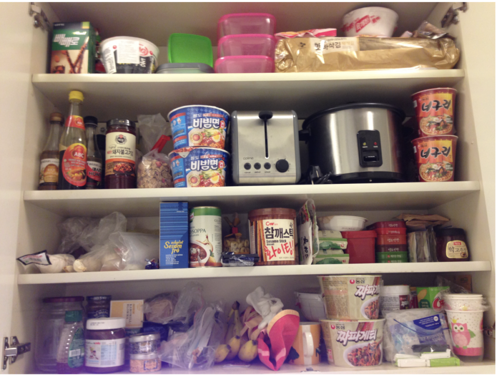 Pantry shelves filled with Korean instant ramen, sauces, seaweed, and cooking ingredients in a student apartment in Sweden