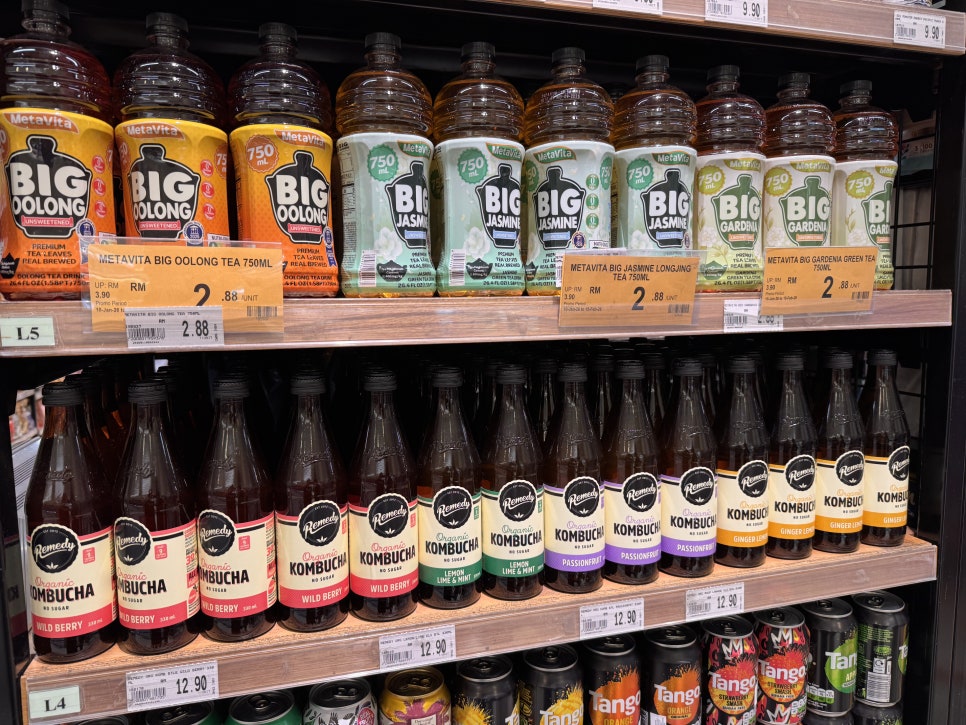 Grocery shelf displaying bottled kombucha and tea drinks in Malaysia.