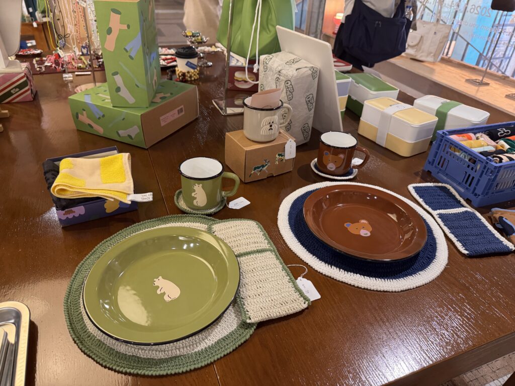 Curated lifestyle items displayed at a shop inside REXKL, including ceramic plates, mugs, textiles, and home goods.