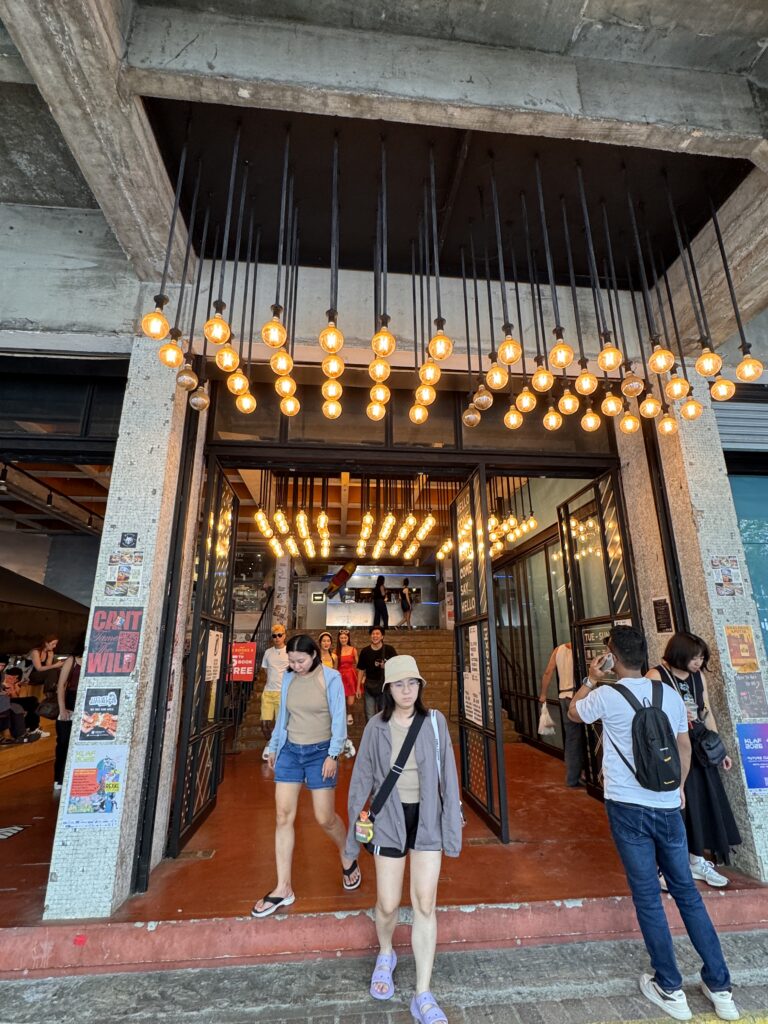 Entrance of REXKL in Kuala Lumpur Chinatown with warm lighting and people walking in and out