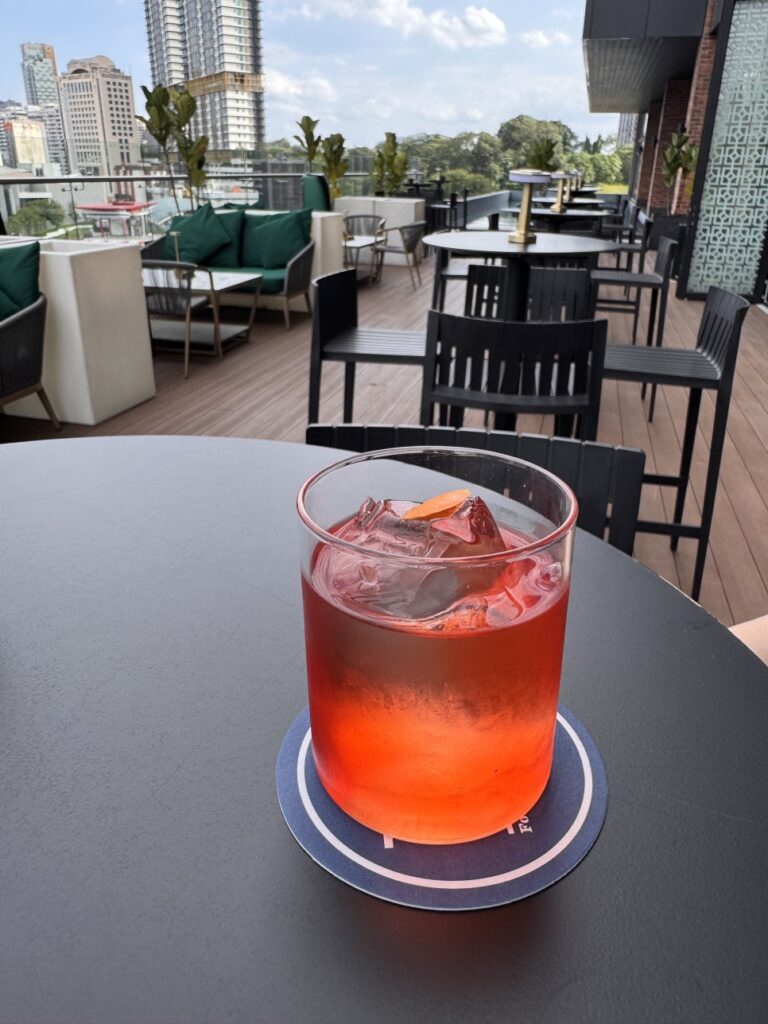 A classic Negroni cocktail with a large ice cube served on a coaster at JANN bar.