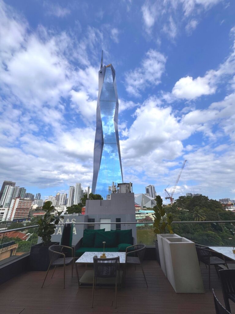 View of the Merdeka 118 skyscraper from the rooftop terrace of JANN bar at night.