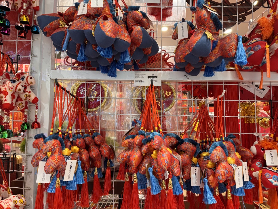 Red and patterned horse hanging ornaments with gold ingot details for Lunar New Year.