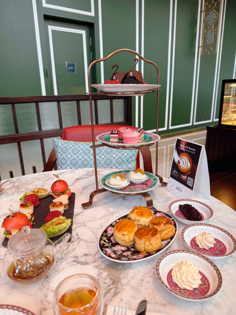 Three-tier afternoon tea set with Peranakan-inspired savory bites, desserts, scones, and tea at Lady Yi’s Tea House.
