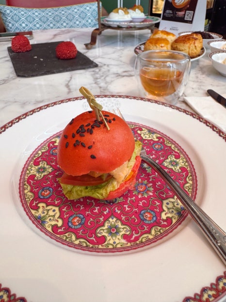Mini burger with a bright red bun served as a savory item in the afternoon tea set.