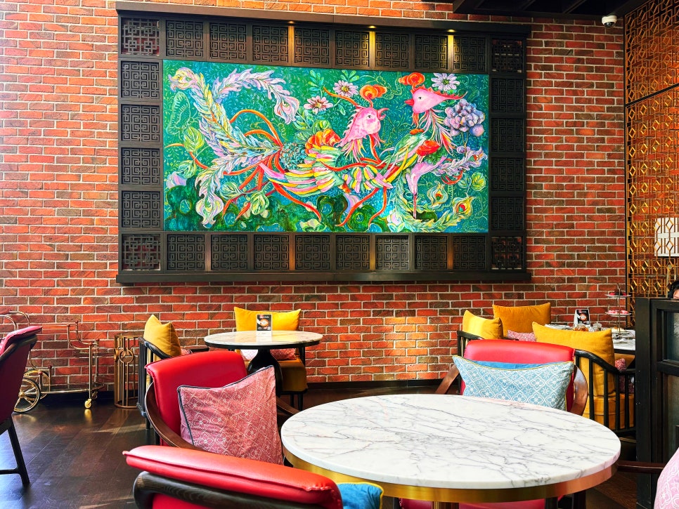 Interior of Lady Yi’s Tea House featuring exposed brick walls, colorful cushions, marble tables, and traditional Chinese design elements.