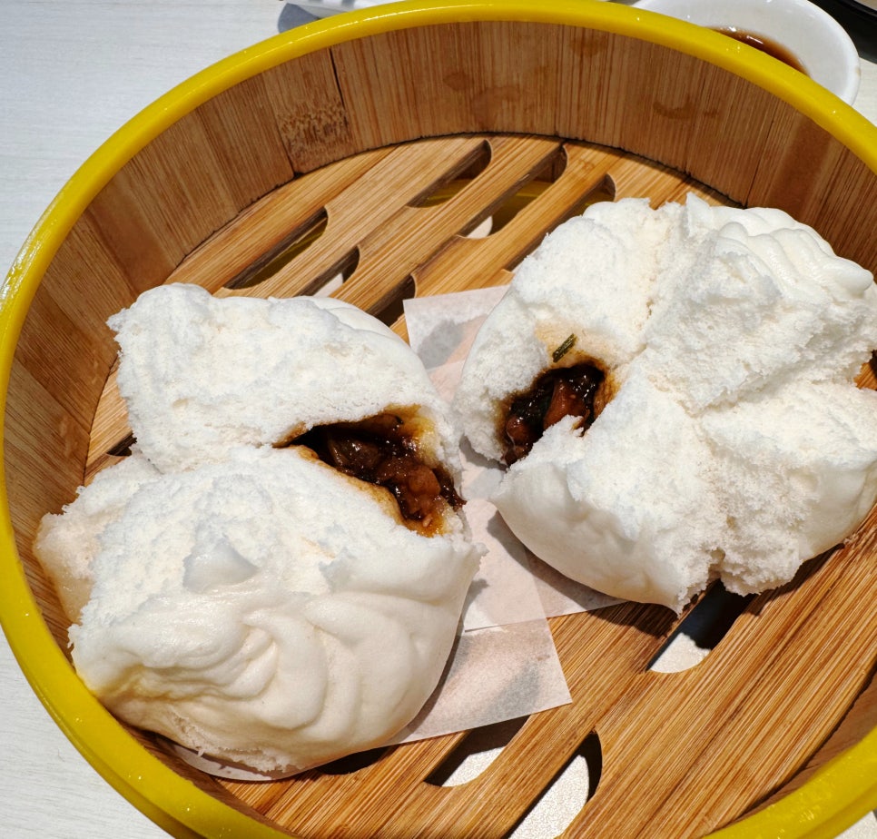 Steamed barbecue pork buns (char siu bao) served in a bamboo basket at Jin Xuan Hong Kong Restaurant