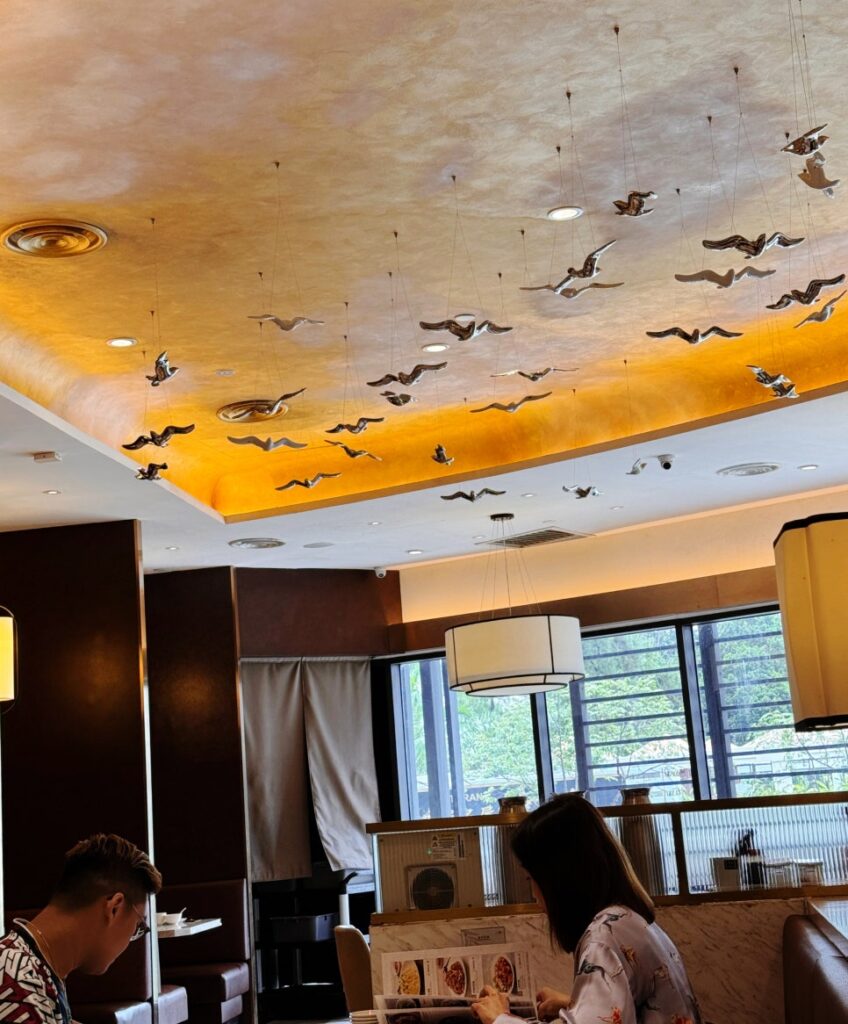 Interior view of Paradise Dynasty restaurant in Sunway 163 Mall, showing bird motifs on the ceiling and a refined dining atmosphere.